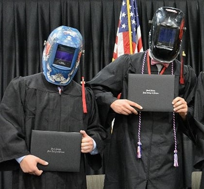 Graduates with diplomas and helmets